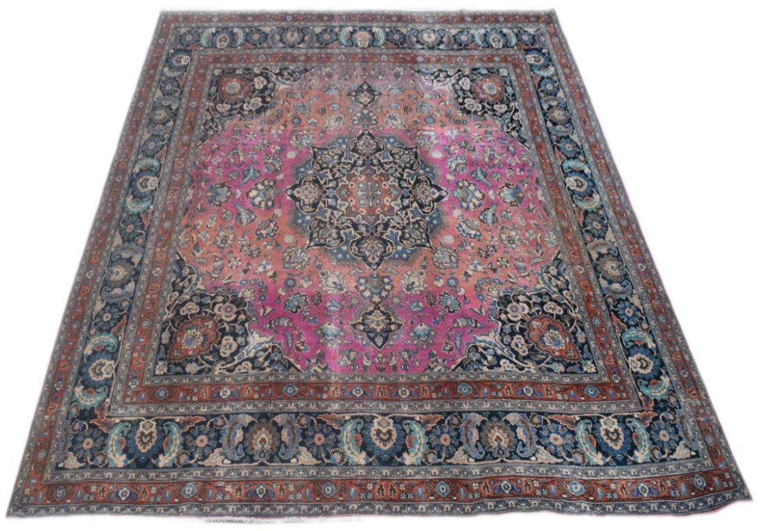 A vintage Persian Bidjar rug featuring a central floral medallion on a pink and orange field.