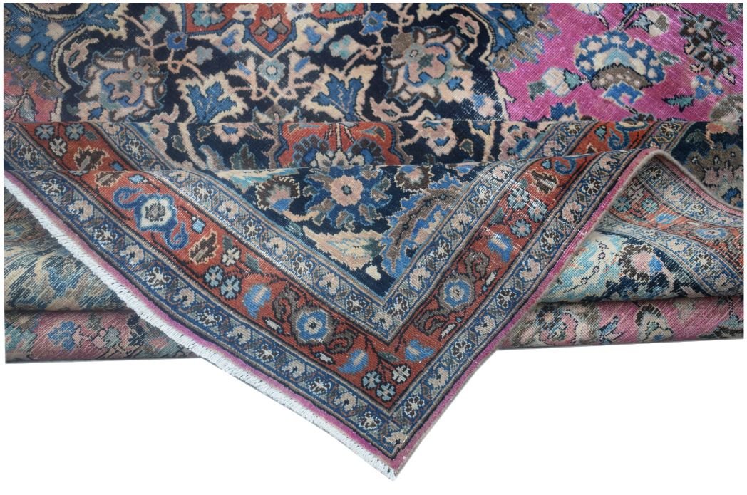 A folded vintage Persian Bidjar rug featuring intricate floral patterns in blue, pink, and rust.