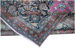 A folded vintage Persian Bidjar rug featuring intricate floral patterns in blue, pink, and rust.