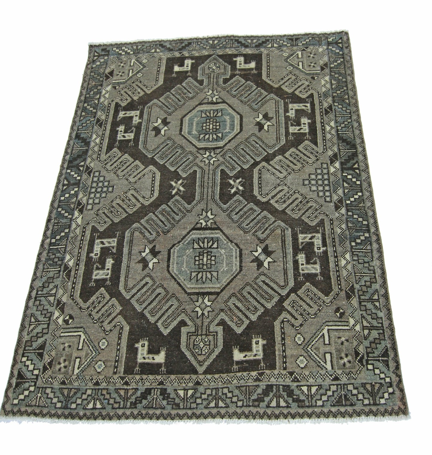A vintage handmade Persian rug featuring a geometric pattern in shades of grey and brown.