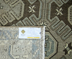 A vintage Persian rug featuring a geometric pattern in shades of brown and grey.