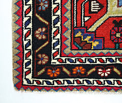 A corner view of a vintage Persian Hamadan rug featuring geometric floral patterns in wool.