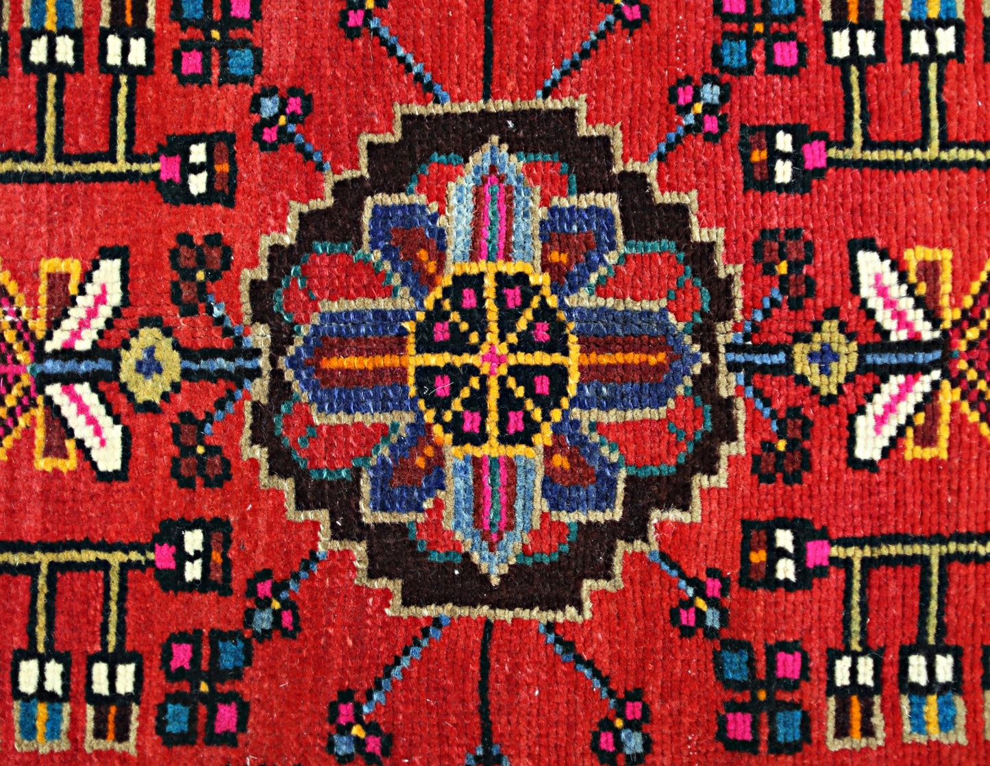 A vintage Persian Hamadan rug featuring a central geometric floral medallion on a red field.