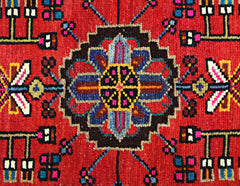 A vintage Persian Hamadan rug featuring a central geometric floral medallion on a red field.