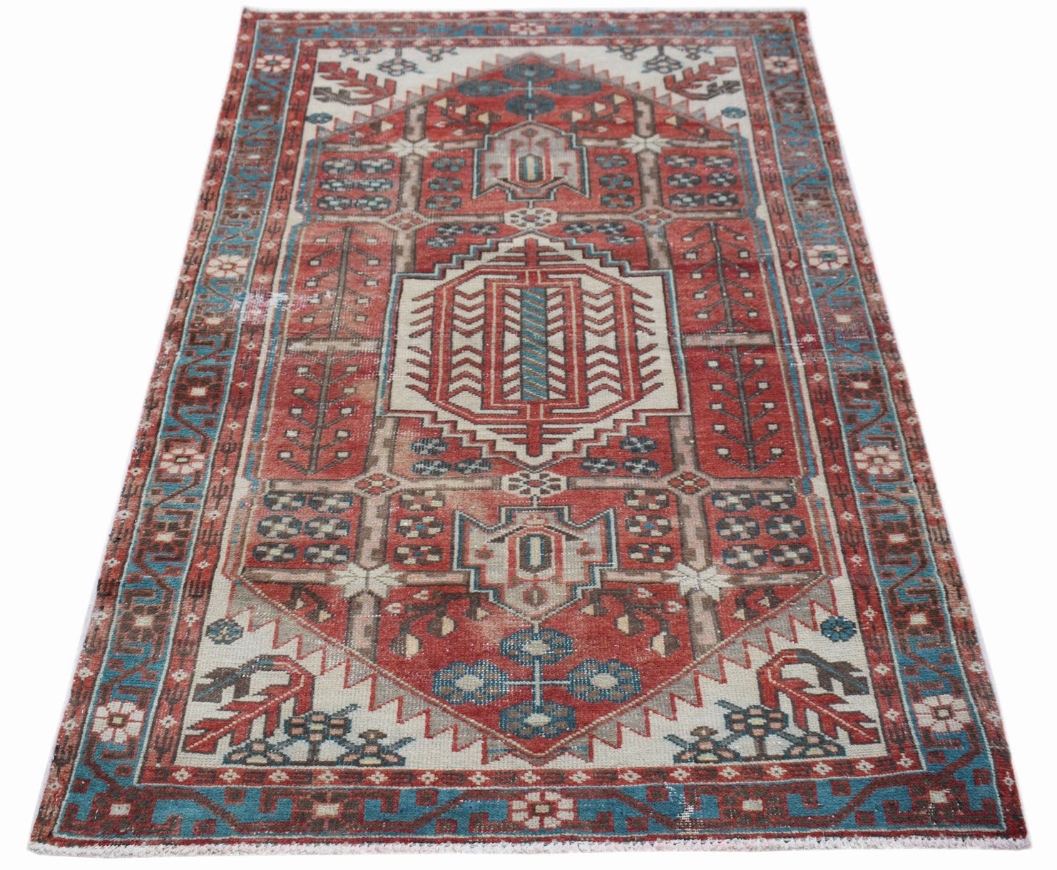 A vintage handwoven Persian Hamadan rug featuring a geometric medallion in red, blue, and cream.
