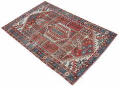 A vintage handwoven Persian Hamadan rug featuring a geometric medallion in red, blue, and cream.