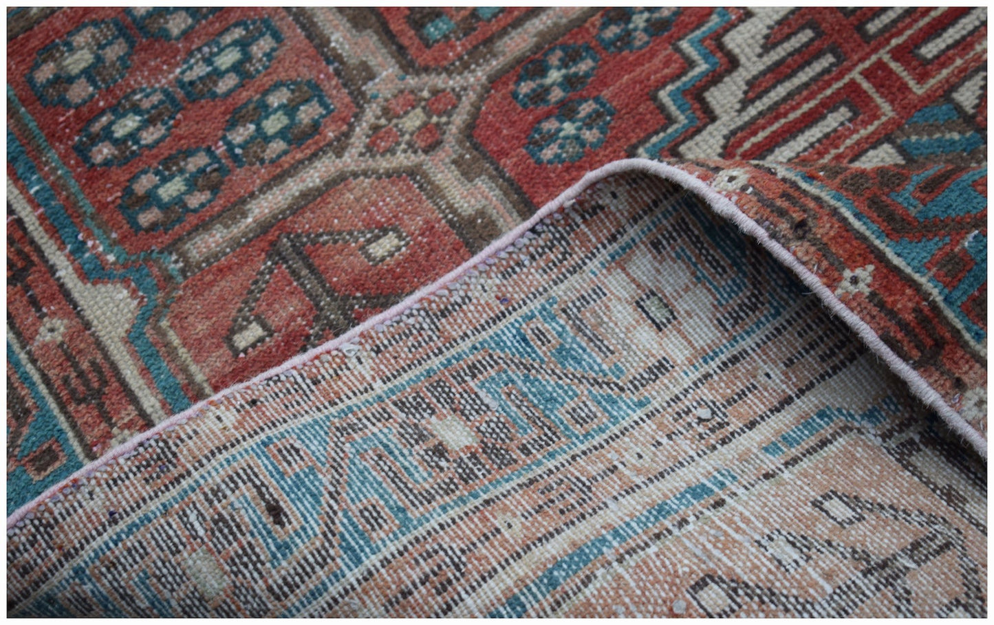 A vintage Persian Hamadan rug with a geometric pattern in red, blue, and cream wool.