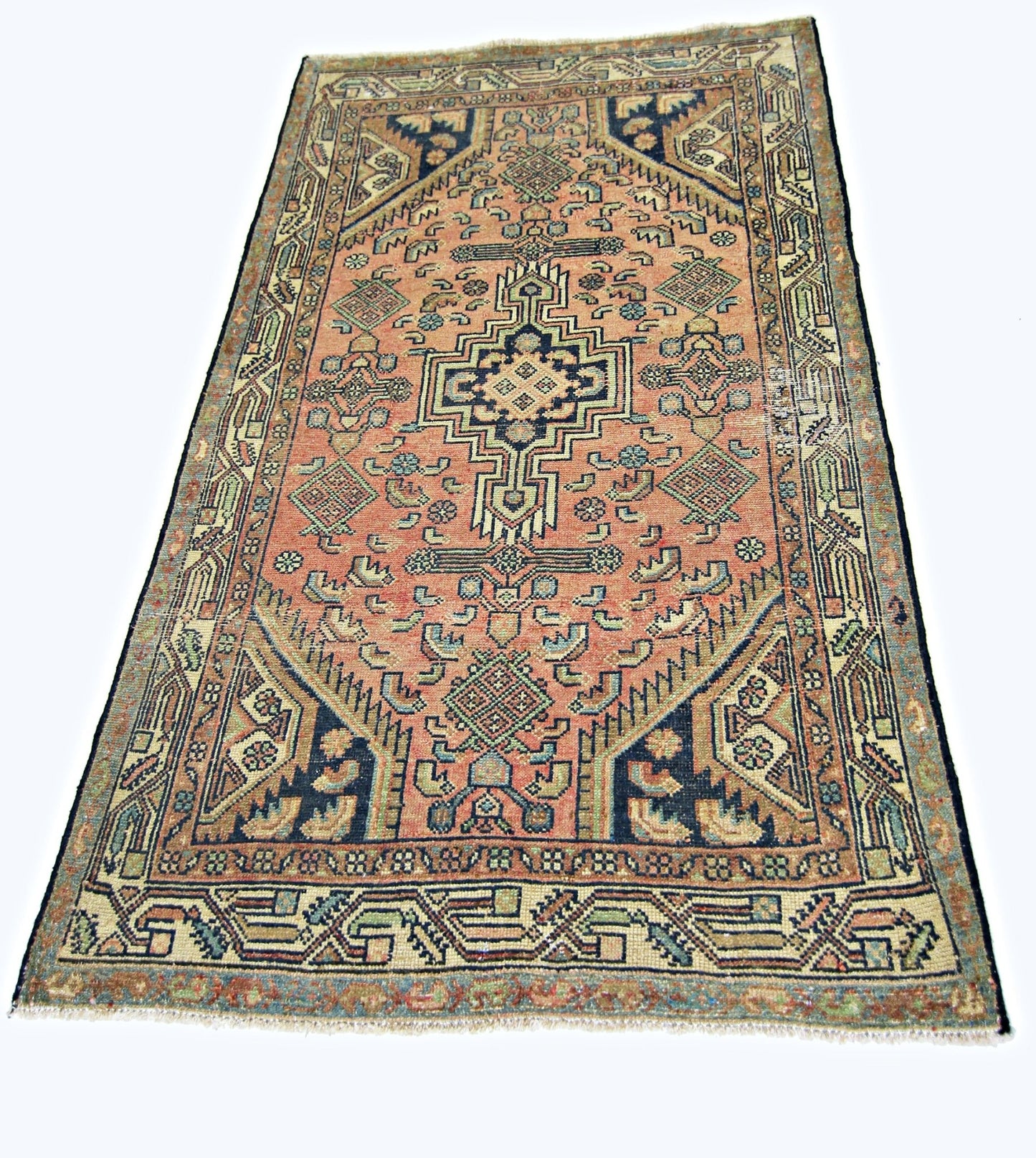 A vintage handmade Persian rug featuring a geometric medallion pattern in muted red and blue tones.