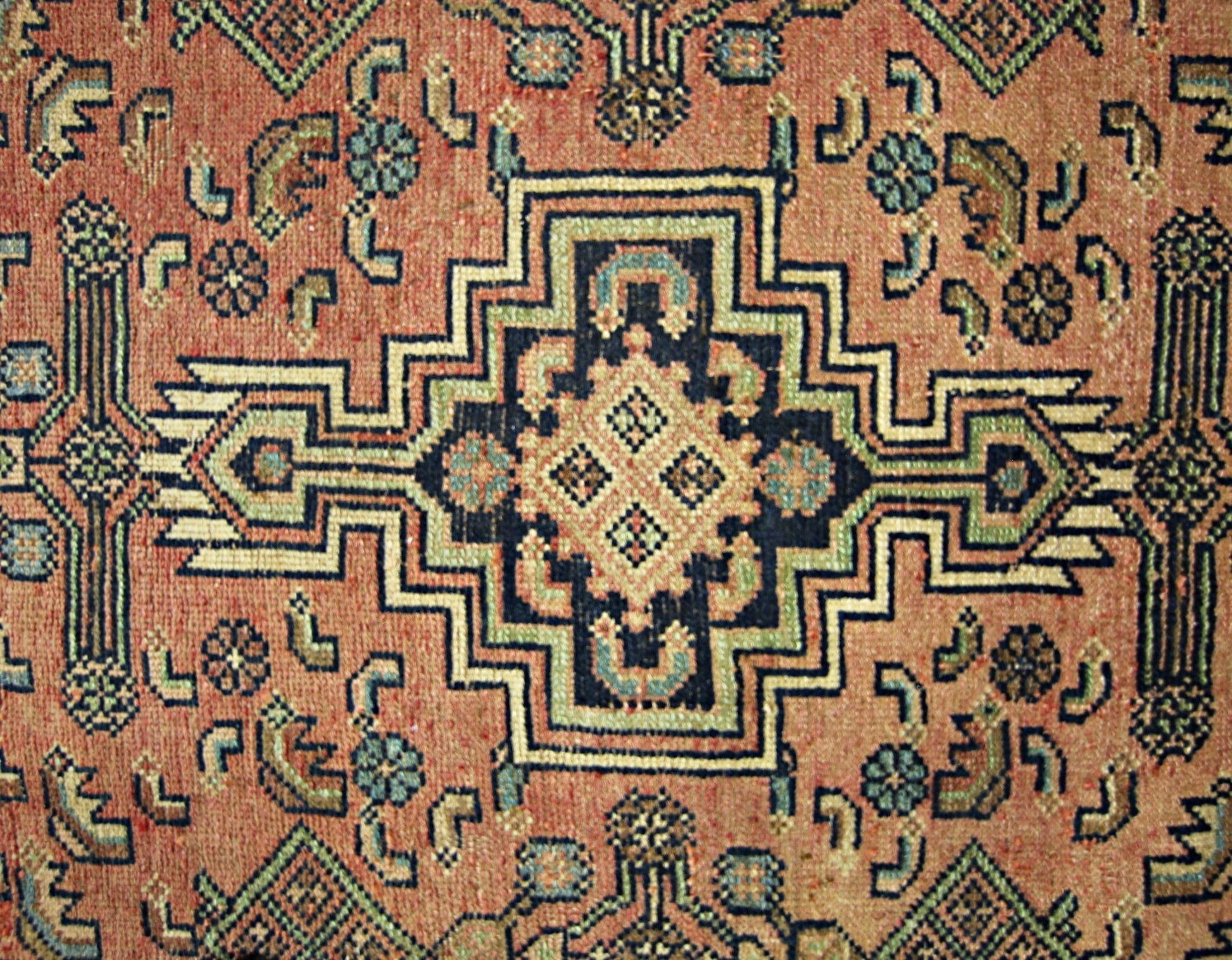 A vintage Persian rug featuring a geometric central medallion in shades of blue, green, and cream.