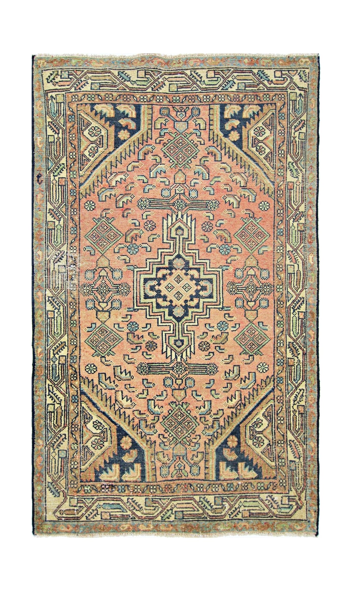 A vintage handmade Persian rug featuring a geometric medallion pattern in salmon and navy blue.