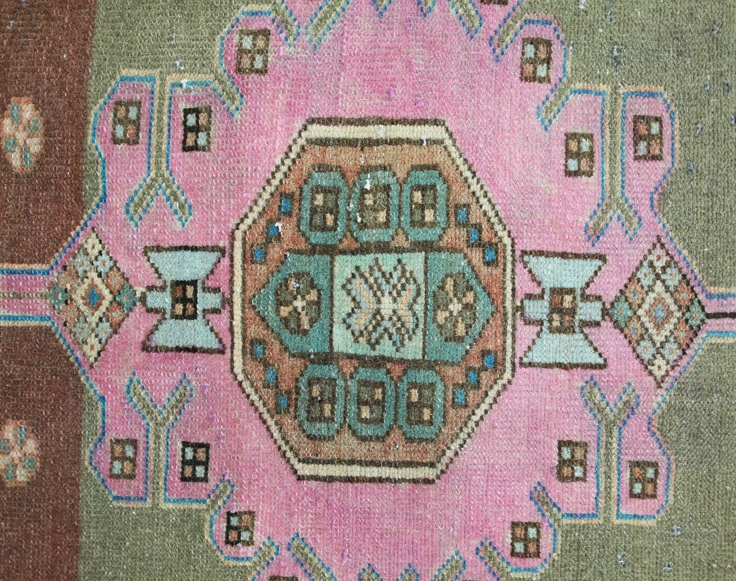 A vintage Persian Hamadan rug featuring a central geometric medallion on a pink and olive field.