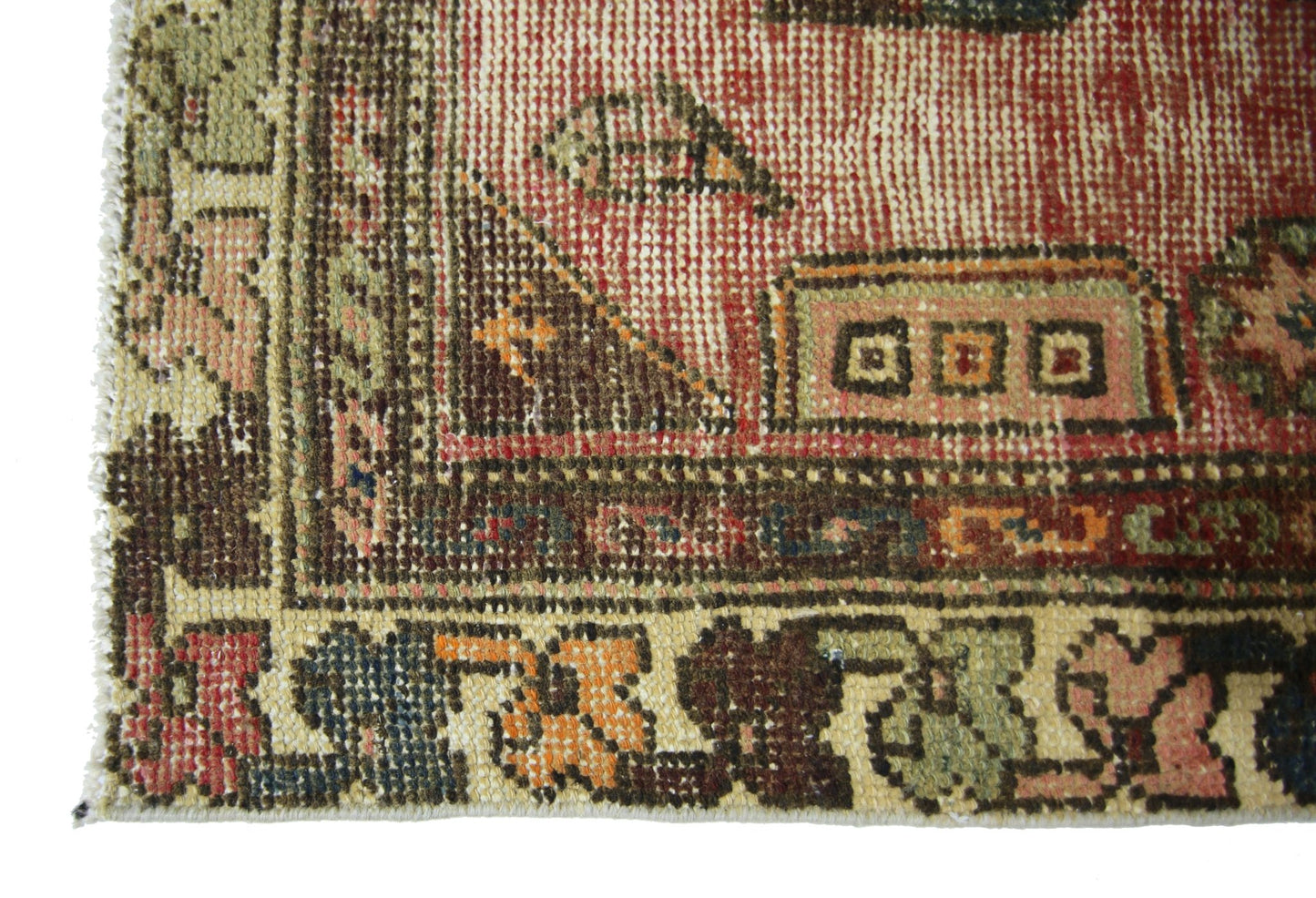 A close-up of a vintage Persian Hamadan rug featuring intricate geometric patterns in warm tones.