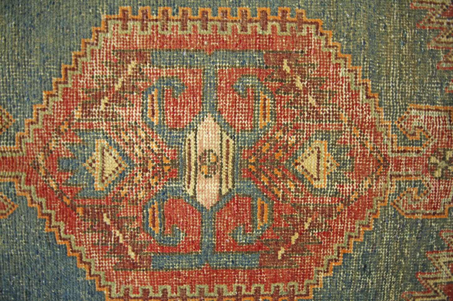 A vintage Persian Hamadan rug featuring a central geometric medallion in red, blue, and cream.