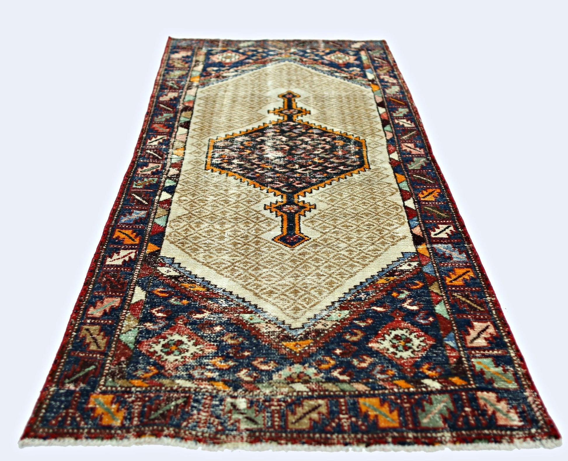 A vintage Persian Hamadan runner rug featuring a central geometric medallion on a beige field.
