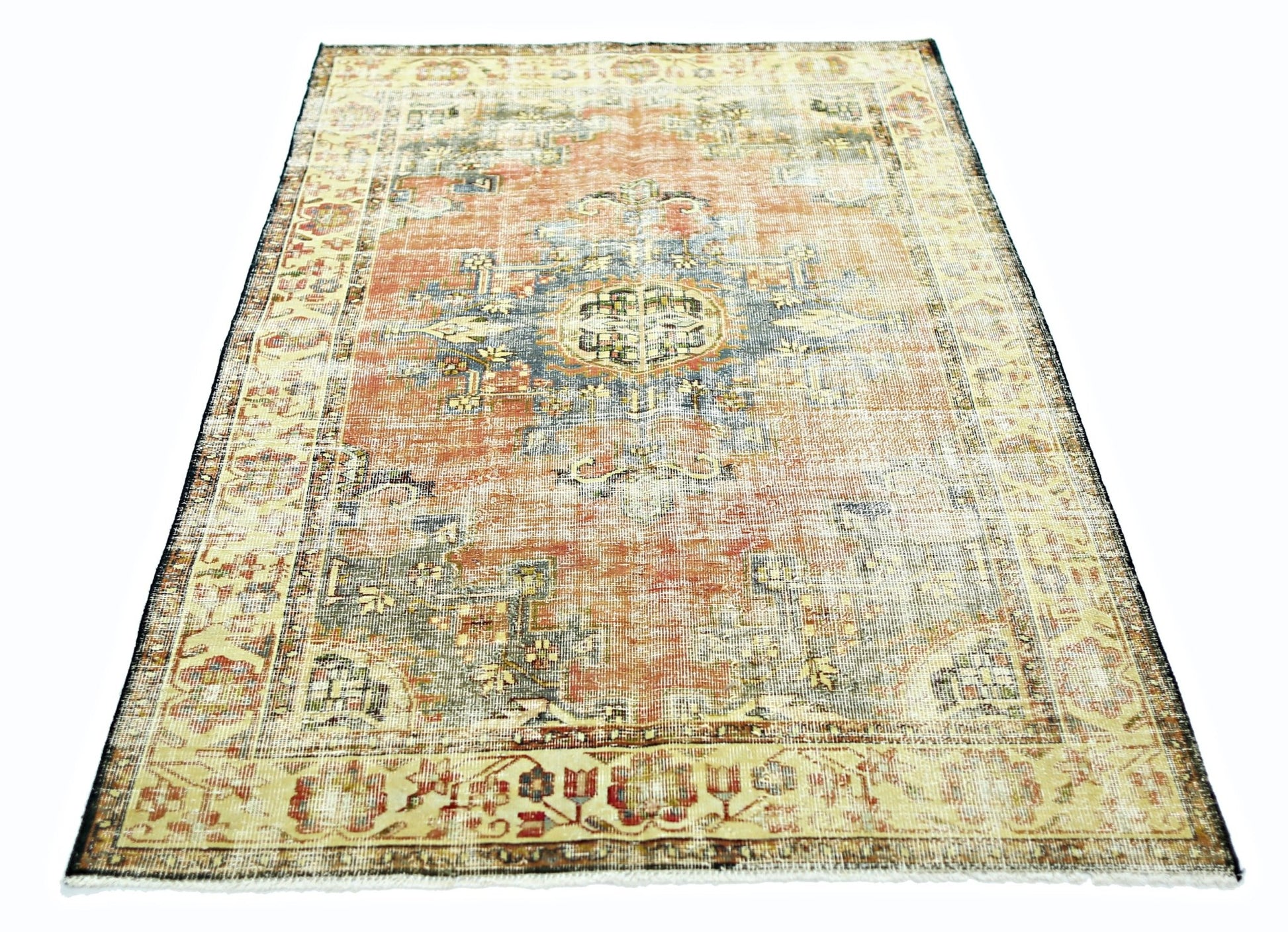 A vintage Persian rug featuring a faded orange and blue floral medallion pattern.