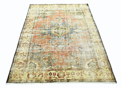 A vintage Persian rug featuring a faded orange and blue floral medallion pattern.
