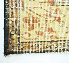 A close-up of a vintage Persian rug featuring a faded floral pattern in red and beige tones.