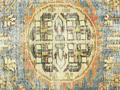 A close-up view of a vintage Persian rug featuring a geometric medallion in muted earth tones.