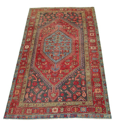 A vintage handmade Persian Hamadan rug featuring a central blue medallion on a red and grey field.