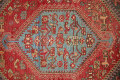 A vintage Persian Hamadan rug featuring a central blue medallion with intricate red geometric motifs.