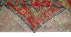 A vintage Persian Hamadan rug with a red and blue geometric pattern folded to show the underside.