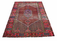 A vintage Persian Hamadan rug featuring a central geometric medallion on a red and blue field.
