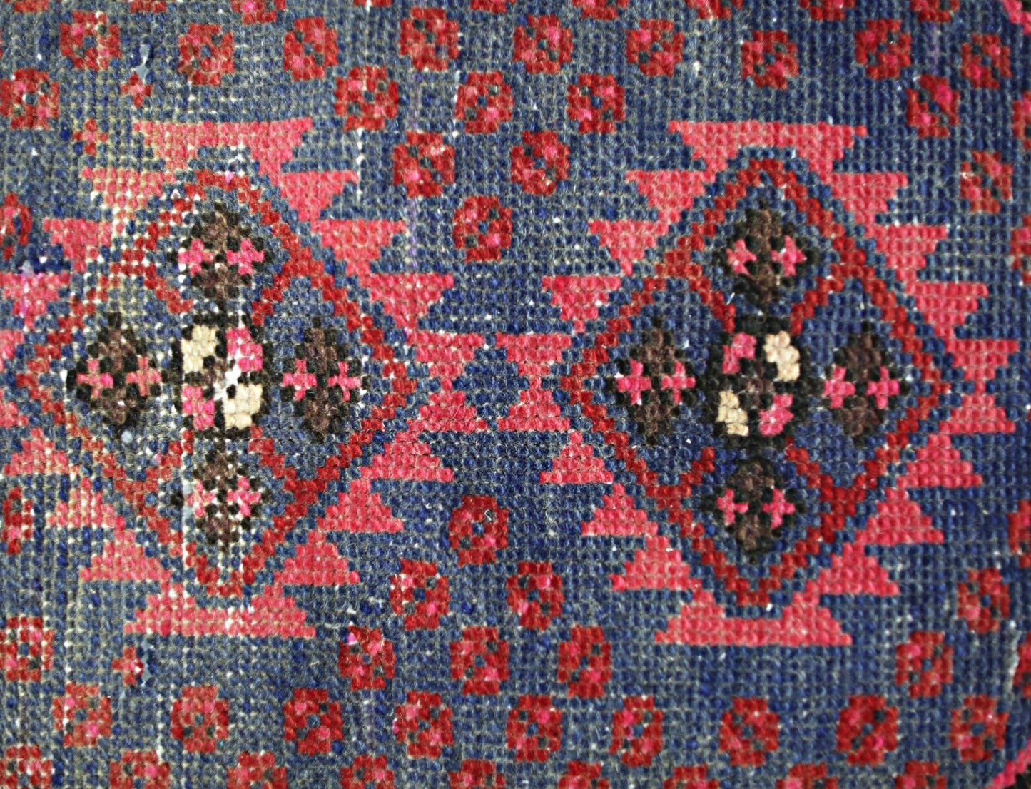 A vintage Persian Hamadan rug featuring a geometric diamond pattern in red, blue, and brown.