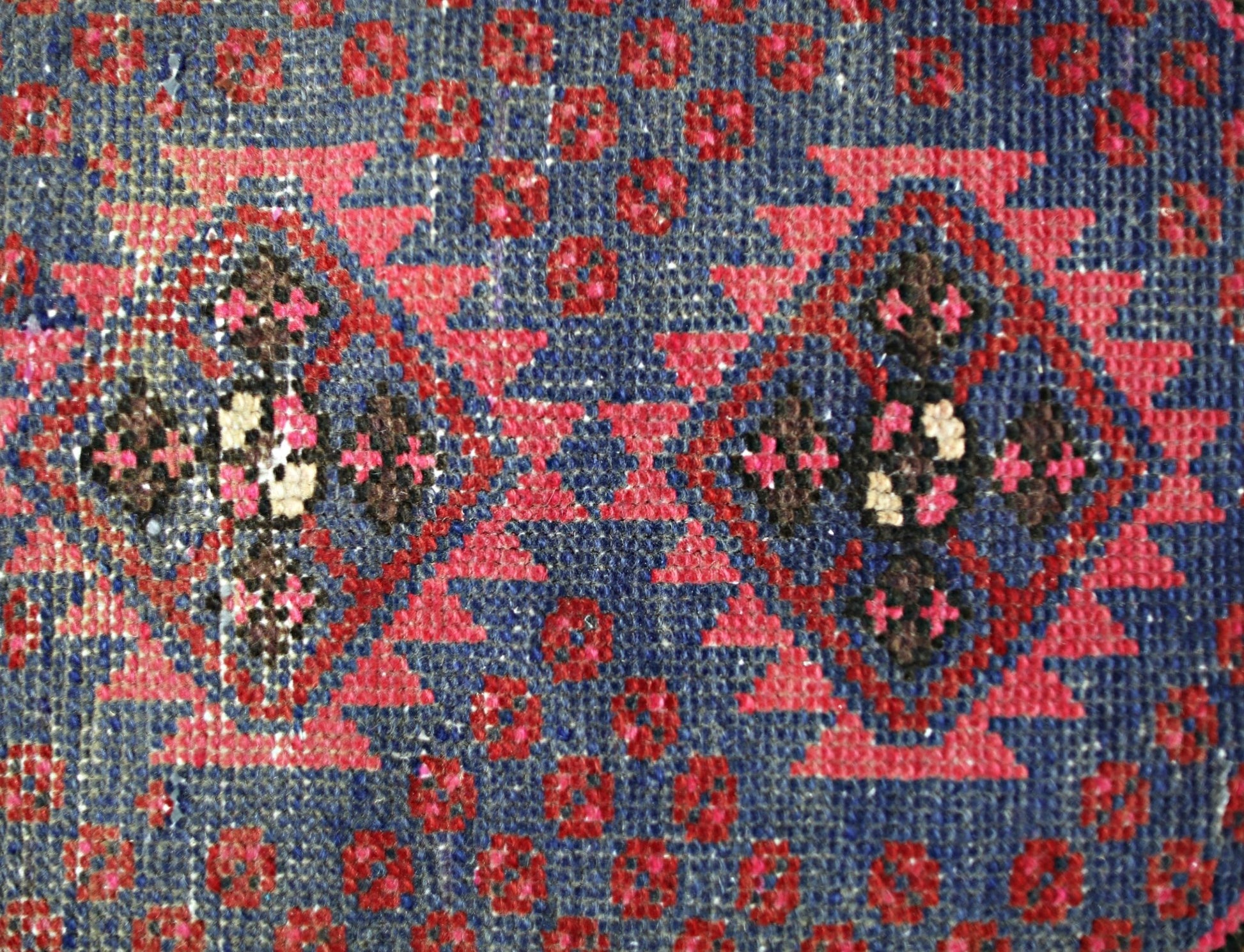 A vintage Persian Hamadan rug featuring a geometric diamond pattern in red, blue, and brown.