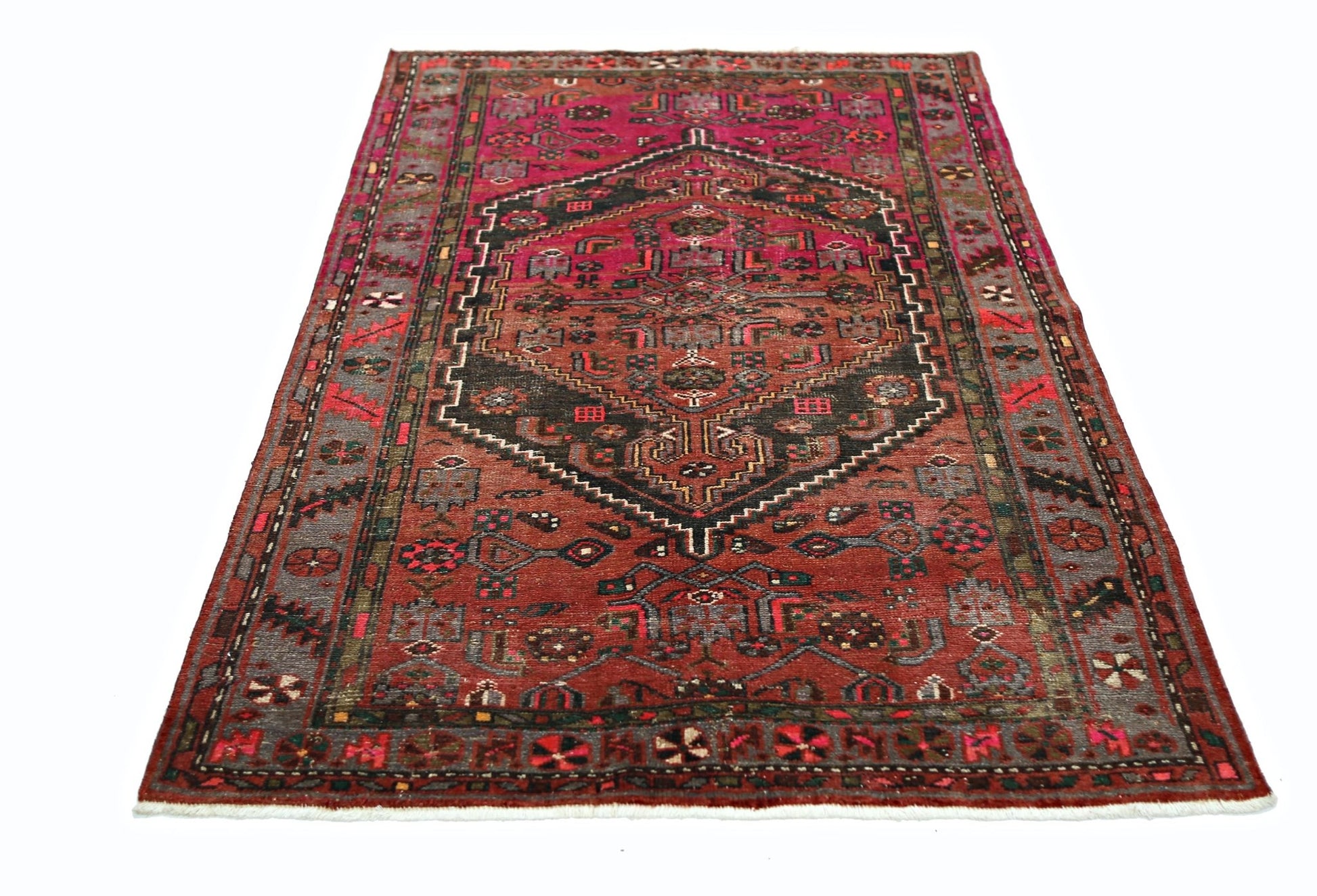 A vintage Persian Hamadan rug featuring a central geometric medallion on a red field.