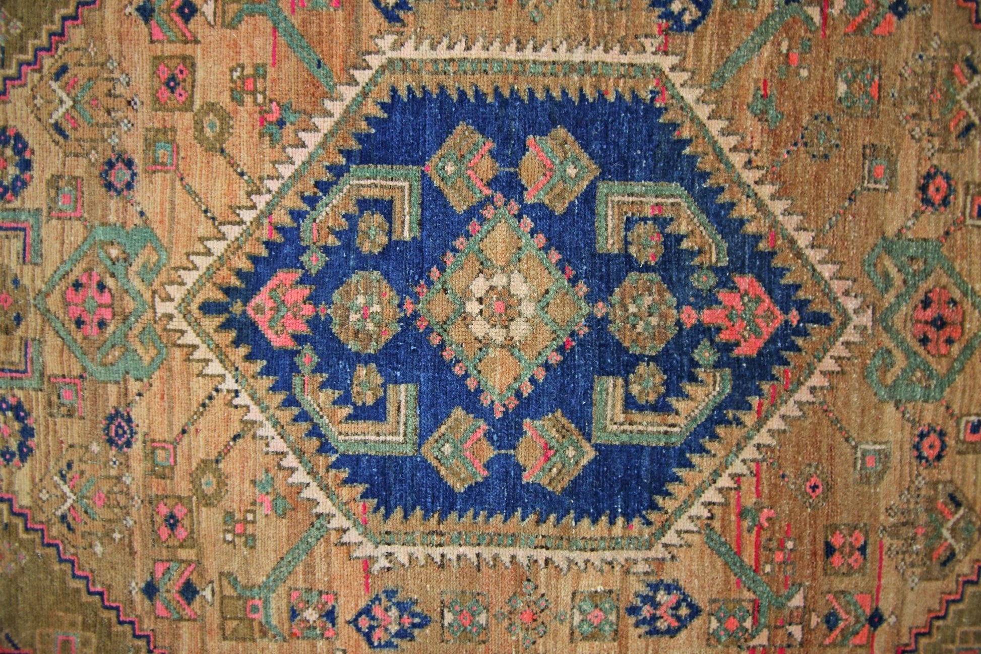 A vintage Persian Hamadan rug featuring a central blue diamond medallion with intricate patterns.