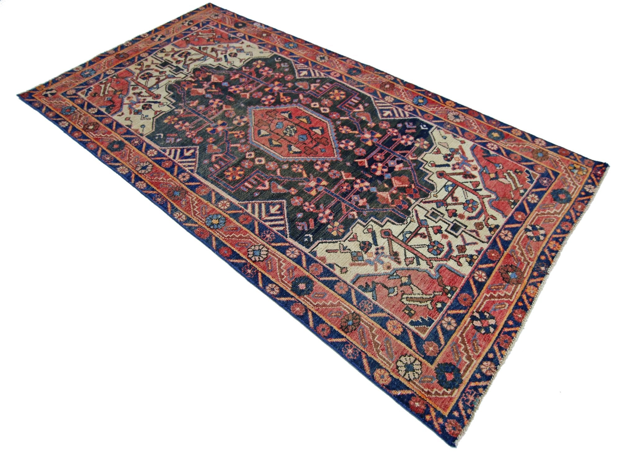 A rectangular vintage Persian rug featuring a dark central medallion with intricate floral patterns.