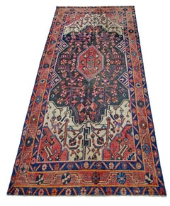 A vintage handmade Persian rug featuring a dark central medallion with intricate floral patterns.
