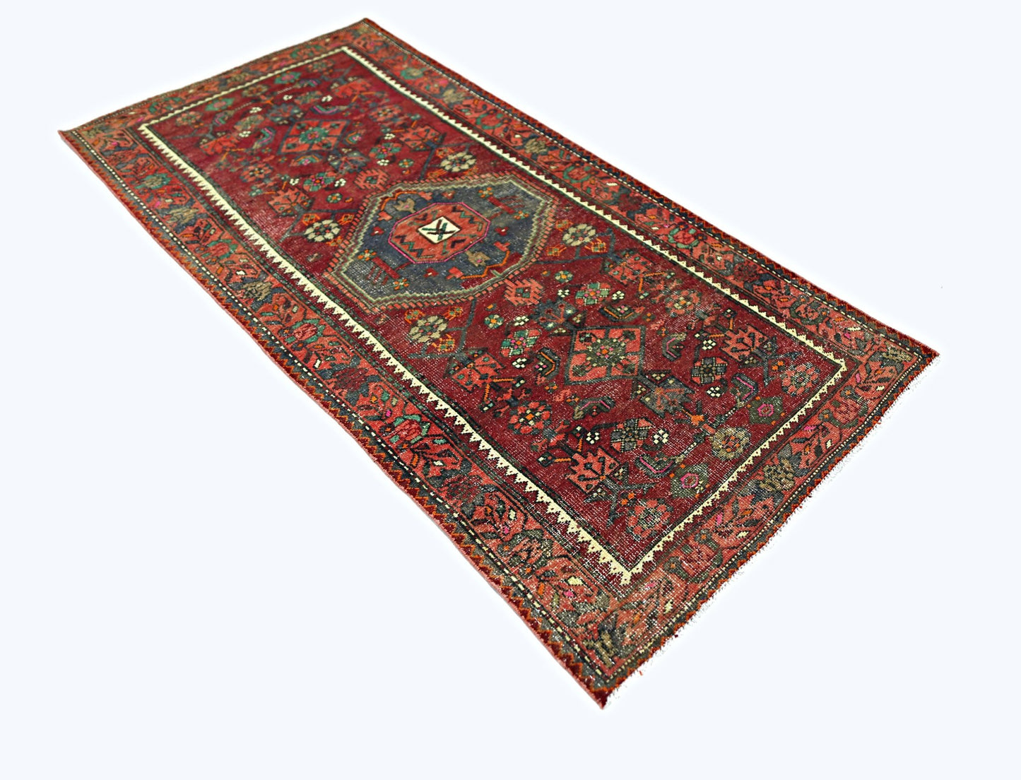 A rectangular vintage Persian rug featuring intricate geometric patterns in red and blue tones.