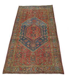 A vintage handmade Persian Hamadan rug featuring a central blue medallion on a red field.