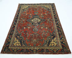 A vintage handmade Persian rug featuring a central medallion on a red field with floral patterns.