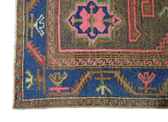 A vintage Persian Hamadan rug featuring a geometric floral pattern in blue, brown, and pink.