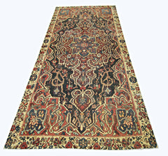 A vintage handmade Persian rug featuring a dark central medallion and intricate floral patterns.