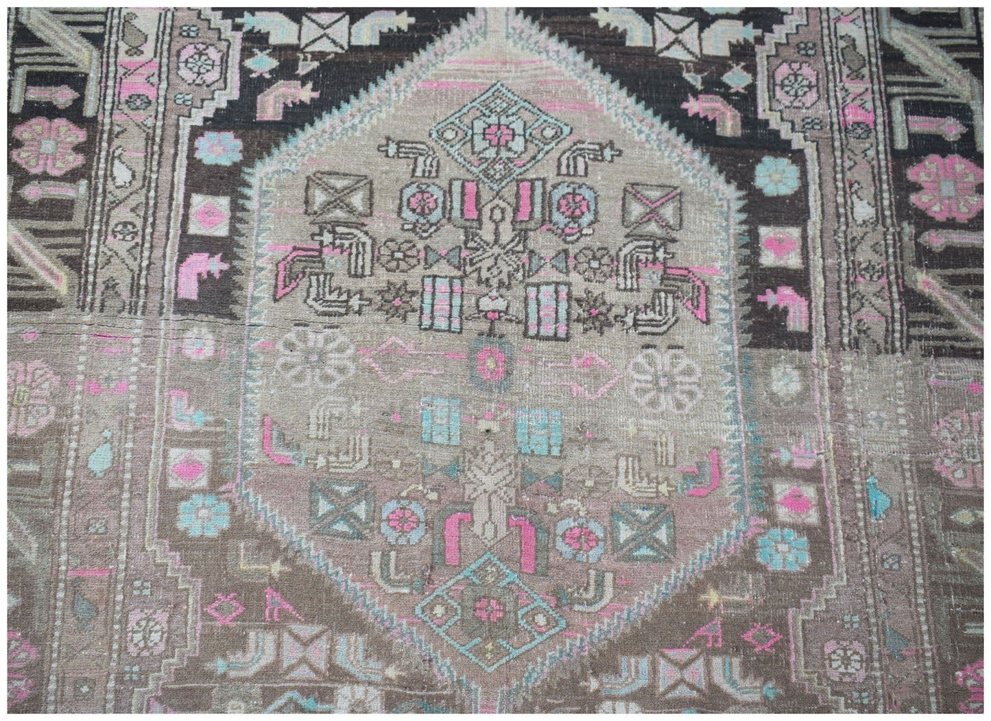 A vintage handwoven Persian Hamadan rug featuring a central medallion in pink, blue, and brown.