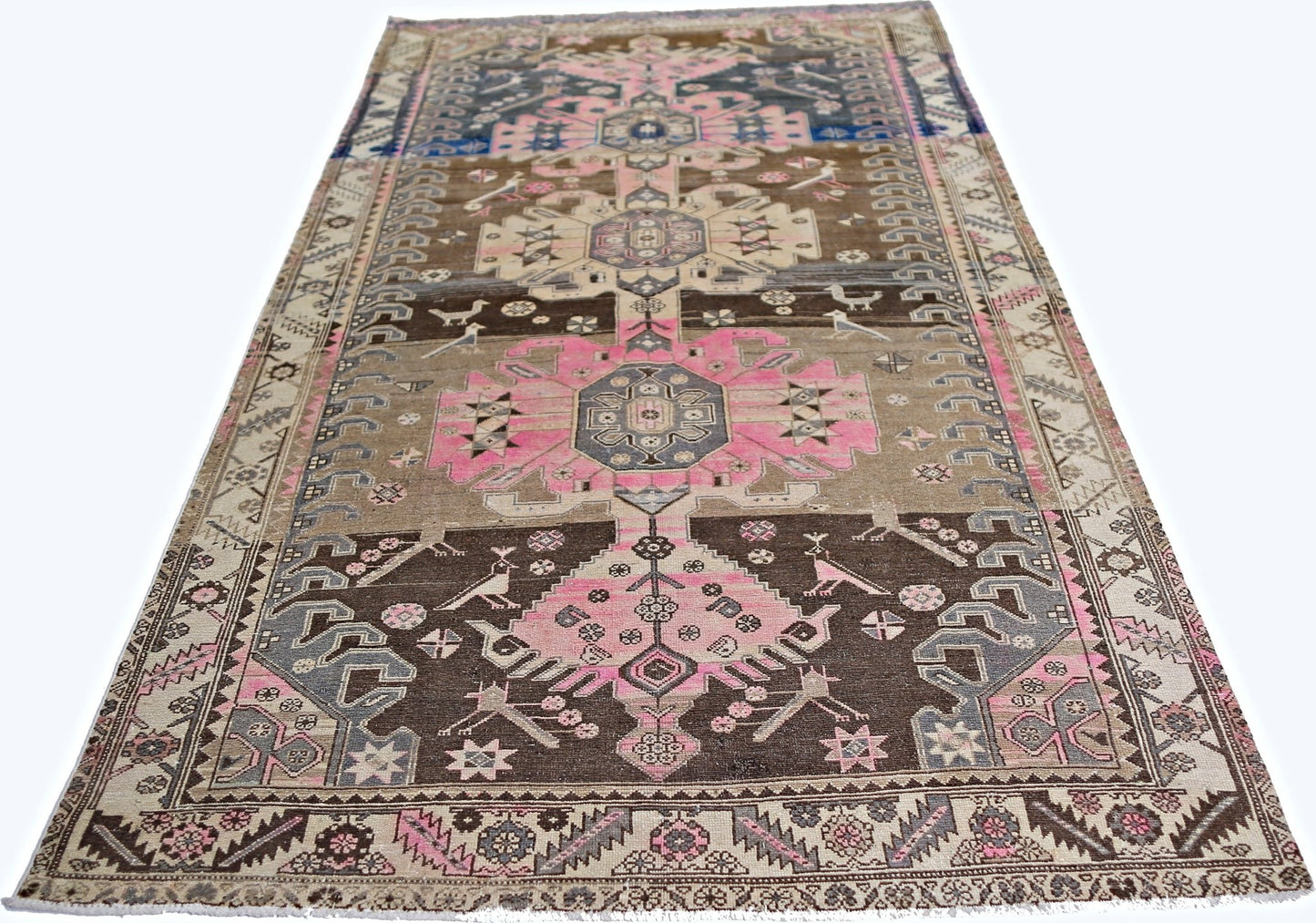 A vintage Persian Hamadan rug featuring geometric floral motifs in pink, brown, and grey tones.