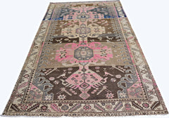 A vintage Persian Hamadan rug featuring geometric floral motifs in pink, brown, and grey tones.