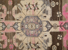 A vintage Persian Hamadan rug featuring a geometric medallion pattern in brown, beige, and pink.