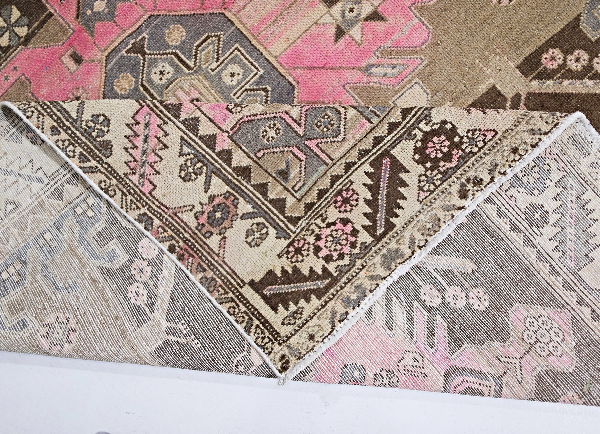 A vintage Persian Hamadan rug featuring a geometric pattern in shades of pink, brown, and cream.