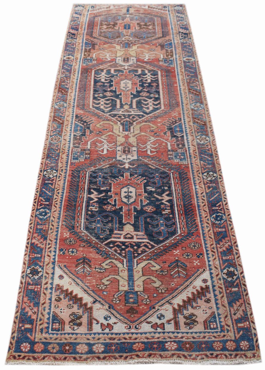 A vintage handwoven Persian Hamadan runner rug featuring geometric patterns in red and blue.