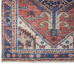 A vintage handwoven Persian Hamadan rug featuring a geometric floral pattern in red and blue.