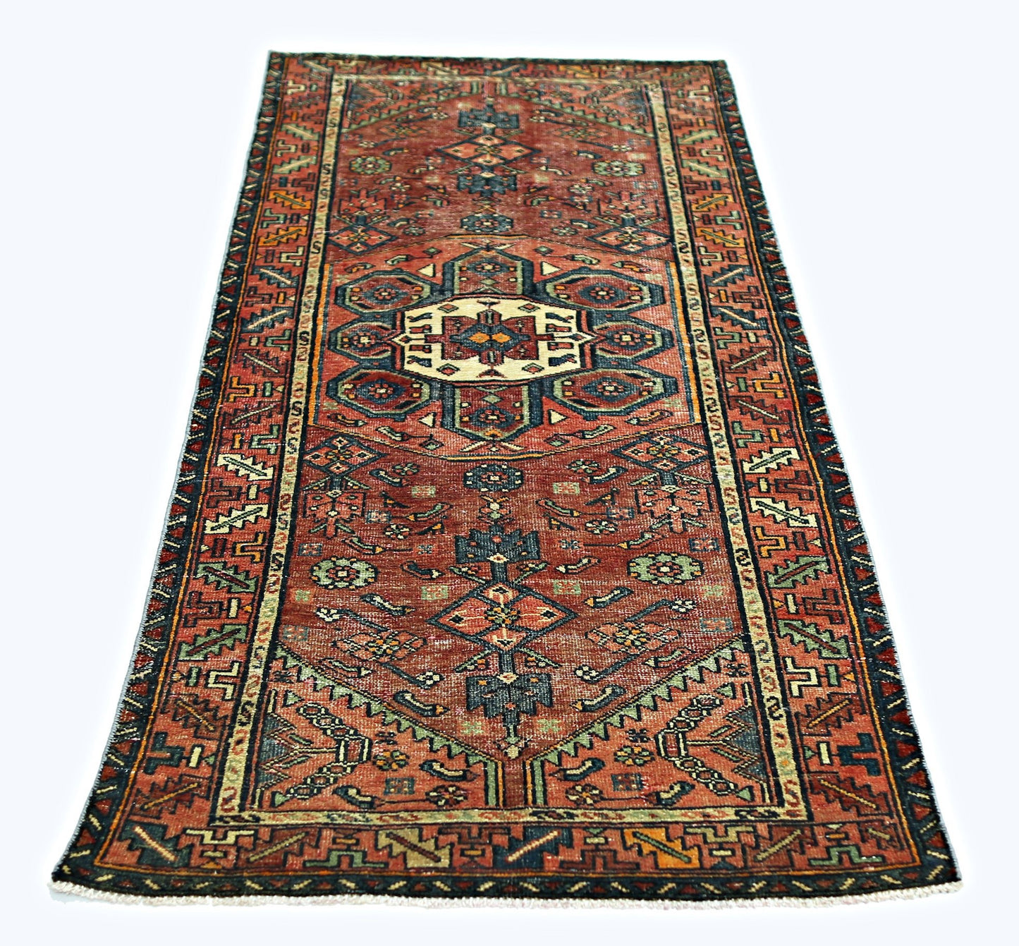 A vintage Persian Hamadan runner featuring a geometric medallion pattern in red, blue, and cream.