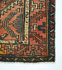 A vintage Persian Hamadan runner featuring geometric patterns in red, blue, and cream wool.