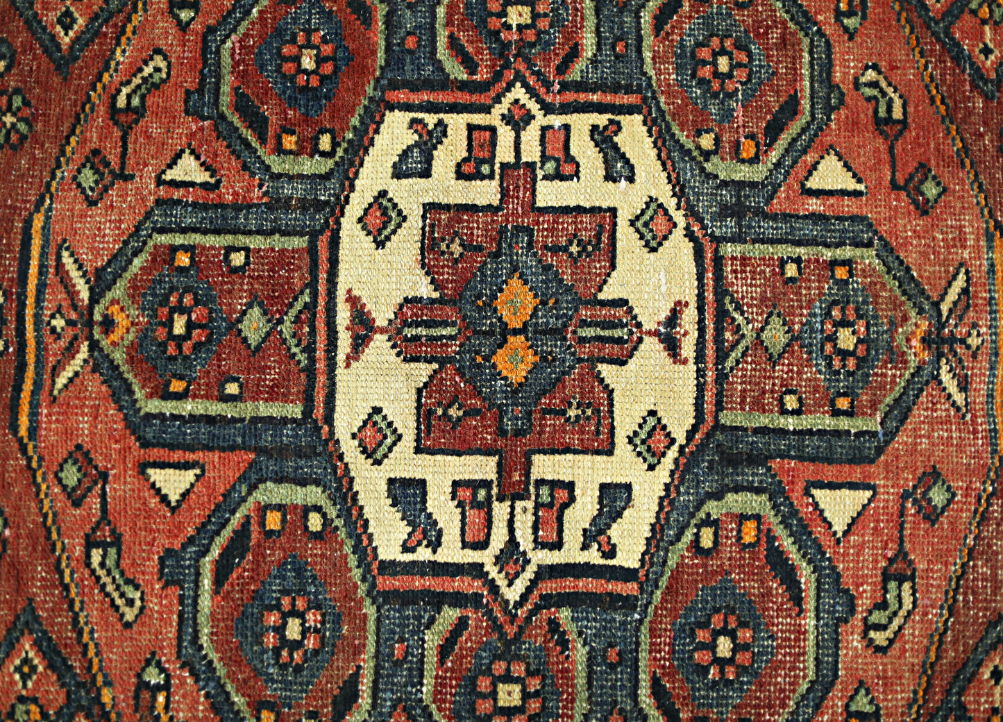 A vintage Persian Hamadan runner featuring a geometric medallion pattern in red, blue, and cream.