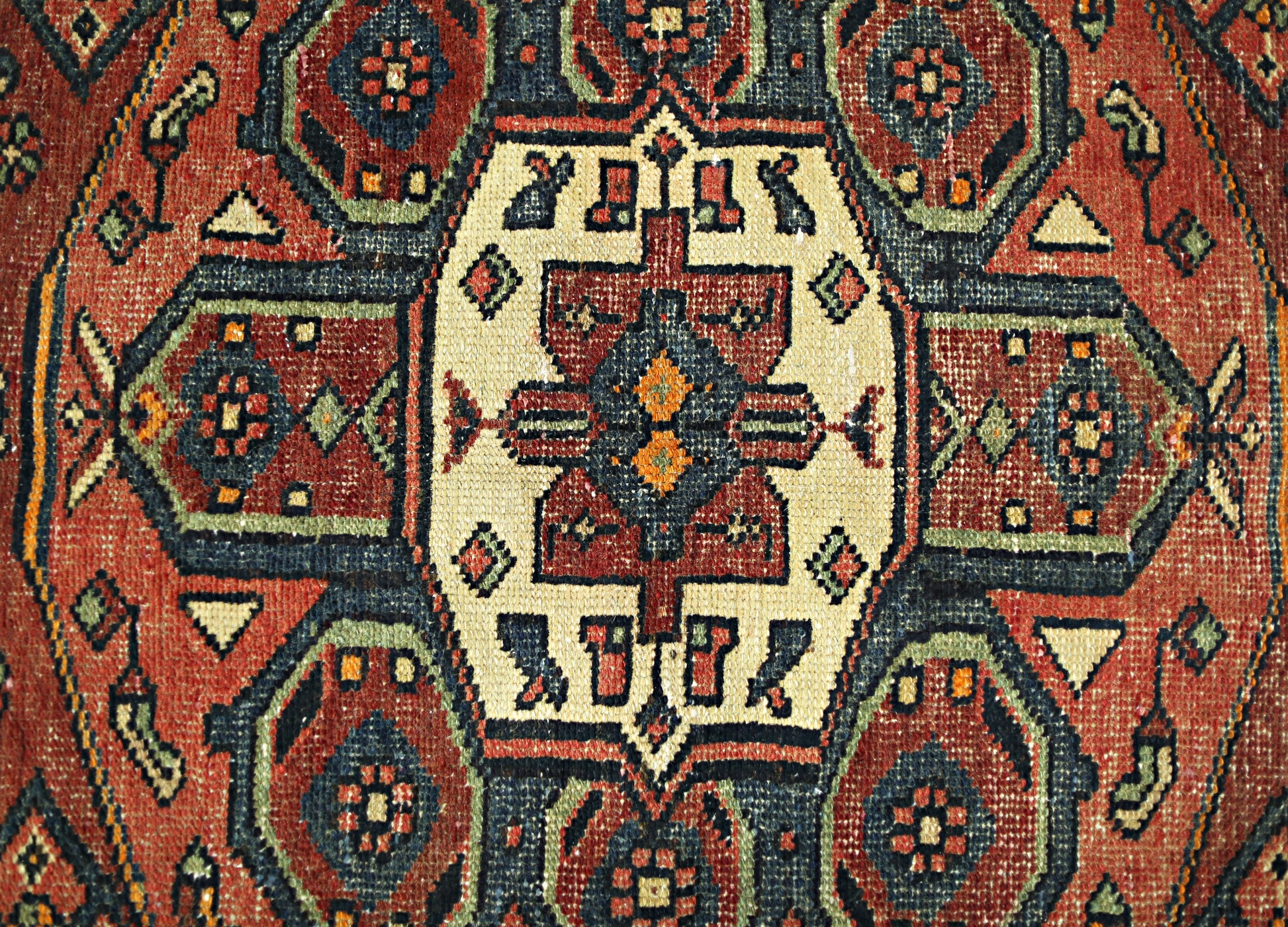 A vintage Persian Hamadan runner featuring a geometric medallion pattern in red, blue, and cream.