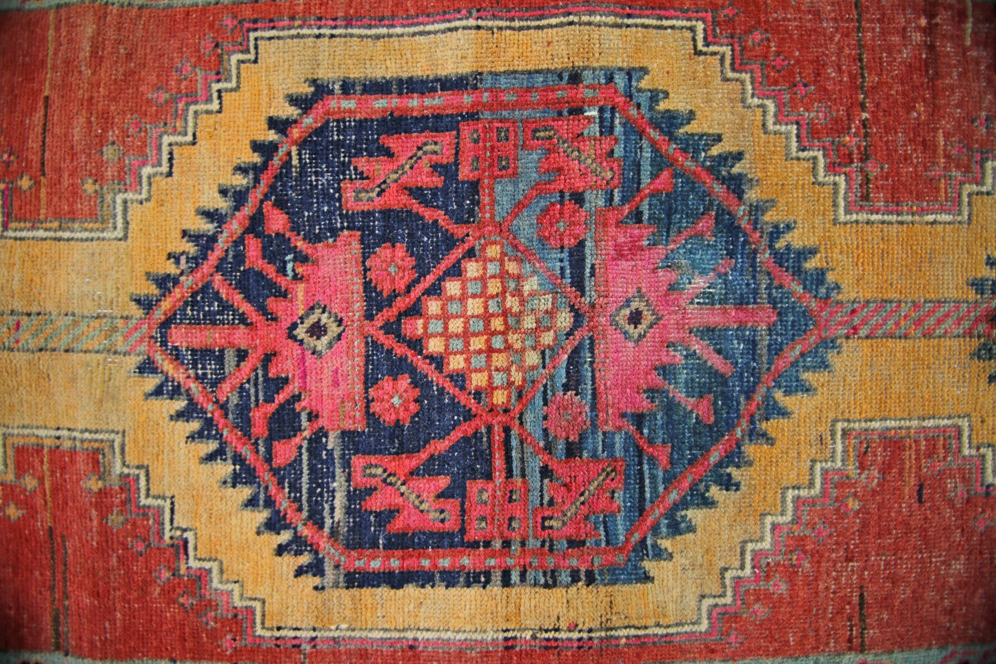 A vintage Persian Hamadan runner featuring a central geometric medallion in red, blue, and gold.