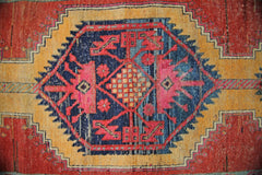A vintage Persian Hamadan runner featuring a central geometric medallion in red, blue, and gold.